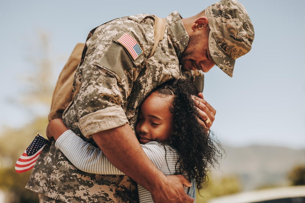 Military dad hugging daughter